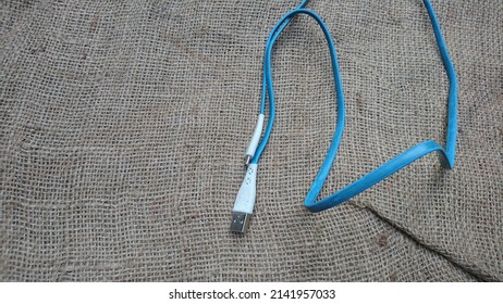 JEPARA, INDONESIA - APRIL 02 2022 : Mobile Phone USB Cable With Gunny Sack Texture Background