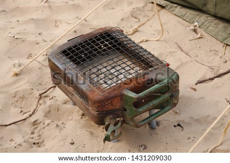 A jerry can that has been modified and being used as a grill cooker