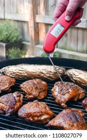 Jersey City, NJ/USA - June 2018: Chicken Thighs On The Charcoal Grill, With Thermometer Measuring The Temperature Of The Meat. 