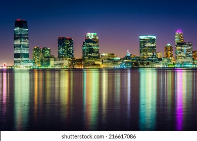 The Jersey City Skyline At Night, Seen From Pier 34, Manhattan, New York.