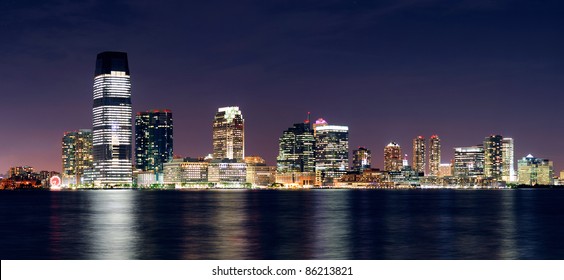 Jersey City Skyline With Skyscrapers At Night Over Hudson River Viewed From New York City Manhattan Downtown.