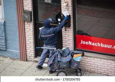 Jersey City, United States - April 9th, 2020: A Postal Worker Continues To Make Deliveries During The Covi-19 Pandemic