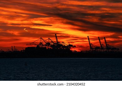 Jersey Port. Sunset View With Crane Silhouettes From The Docking Yard Between Staten Island And Manhattan, New York. Cargo Transportation And Shipment Industry.