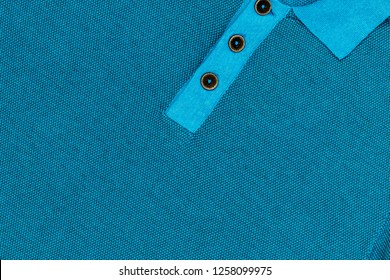 Jersey-Poloshirt With Brown Wooden Buttons. Jersey Polo Shirt Clasp With Brown Wooden Buttons. Blue Polo Shirt, Close Up Fashion Background.  