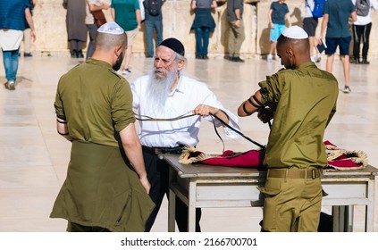 Jerusalem, Israel, 15 April, 2022: Tefillin ritual performed in front of Sacred Western Wall in Jerusalem Old City Jewish Temple