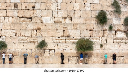 Jerusalem, Israel - August 20, 2020 -Jewish orthodox believers reading the Torah and praying facing the Western Wall, also known as Wailing Wall in the old city in Jerusalem, Israel. 
