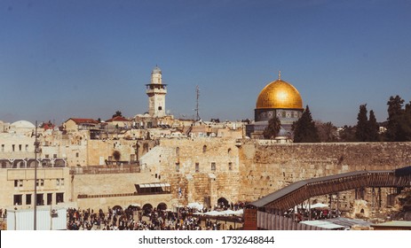 Jerusalem, Israel - February 13 2020 : Believer standing in front of the Western Wall with the Al-Aqsa Mosque in the background during a sunny day