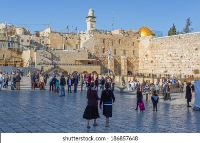 JERUSALEM, ISRAEL - FEBRUARY 28, 2014: Tourists and prayers visiting and making their wishes at The Western Wall, Wailing Wall or Kotel witch is located in the Old City near the Temple Mount.