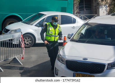 JERUSALEM, ISRAEL- JULE 12, 2020: Policeman Wearing Protective Mask Checks The Car.