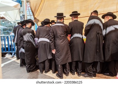 JERUSALEM, ISRAEL - SEPTEMBER 20, 2018: Pre-holiday Bazaar. Orthodox Jews With Sidelocks In Black Hats Choose Ritual Plants For The Holiday Of Sukkot. 