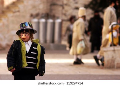 JERUSALEM - MARCH 15 2006:Ultra-orthodox Jewish Child Wearing A Funny Face Mask Celebrating Purim Jewish Holiday In Mea Shearim In Jerusalem, Israel.