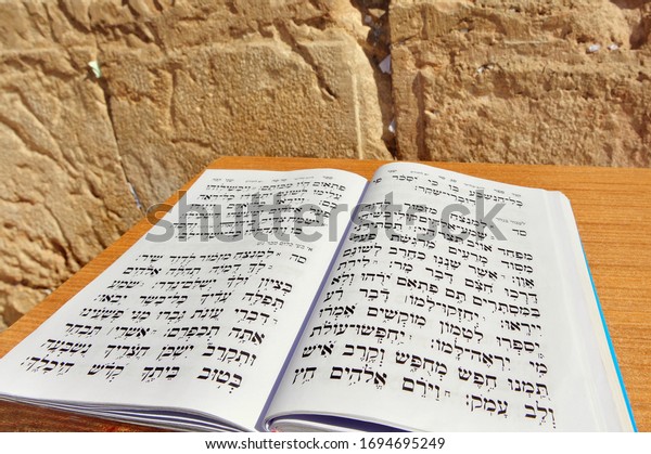 JERUSALEM-NOV 05 2010:King David Book of Psalms\
in Hebrew against the Wailing Wall. The Messiah will be a\
patrilineal descendant of King David, and will gather the Jews back\
into the Land of\
Israel.