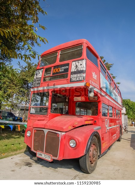 Jessada Technic Museum, Nakhon Pathom -THAILAND,\
Nov.23, 2009 : view of red vintage bus with old poster banner\
advertise around bus\
body