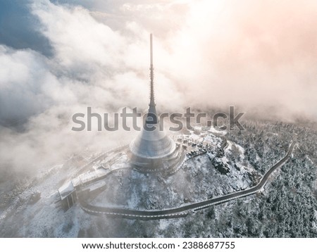 Jested mountain with modern hotel and TV transmitter on the top, Liberec, Czech Republic. Building in clouds. Aerial view from drone.