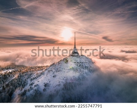 Jested tower mountain hill with snow mist and fog at golden hour