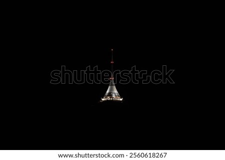 Jested Tower stands elegantly lit against the darkening sky of Liberec, Czechia, showcasing its unique architectural design during the tranquil evening hours.
