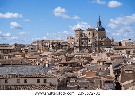 Jesuit Church of San Ildefonso seen between the rooftops of the city of Toledo, Spain, on a sunny day with few clouds. UNESCO World Heritage Site