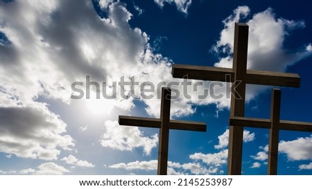 Jesus Christ cross. Easter, resurrection concept. Christian wooden cross on a background with dramatic lighting, colorful mountain sunset, dark clouds and sky, sunbeams.