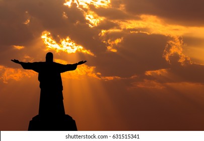 Jesus Christ on a Cross with cloud at sunset