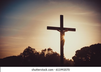 Jesus Christ on the cross silhouette at sunset - crucifixion on the Calvary Hill. Good Friday passion or Lent background.