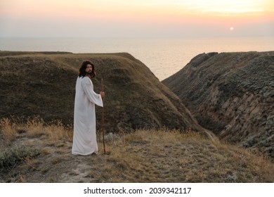 Jesus Christ on hills at sunset. Space for text - Shutterstock ID 2039342117