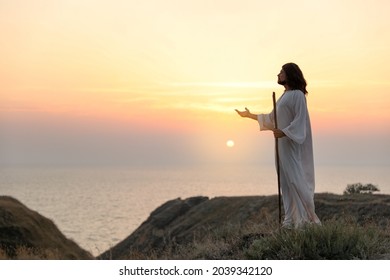 Jesus Christ on hills at sunset. Space for text - Shutterstock ID 2039342120