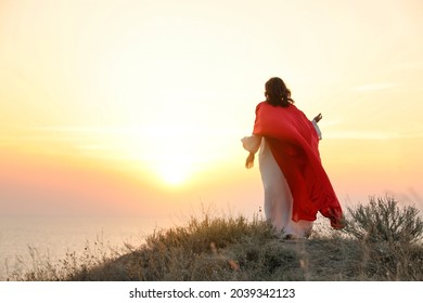 Jesus Christ on hills at sunset, back view. Space for text - Shutterstock ID 2039342123