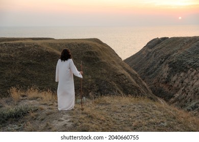 Jesus Christ on hills at sunset, back view. Space for text - Shutterstock ID 2040660755