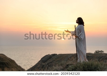 Jesus Christ on hills at sunset. Space for text