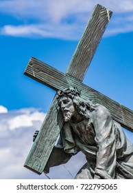 Jesus Christ statue carrying the cross with pain