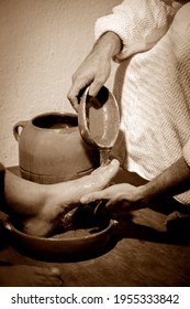 Jesus Christ washing the feet of his apostles in a sign of service and humility. Sepia tones.