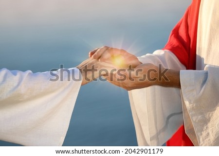 Jesus Christ and woman near water outdoors, closeup. Miraculous light in hands