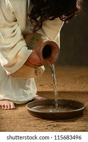 Jesus pouring water into container over dark background