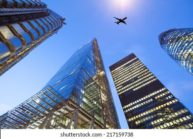 A jet airplane silhouette with business office building towers in London