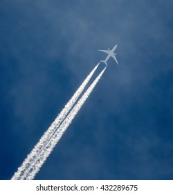 Jet airplane in the sky, leaving vapor trails behind in flight
