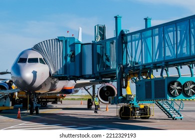 Jet Bridge At The Airport Is Brought To A Large Passenger Plane For Passengers To Exit