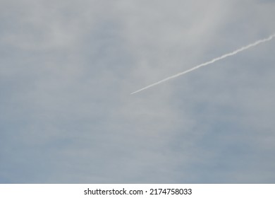 Jet Contrail In Cloudy Sky