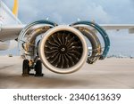 Jet engine. A modern, new generation, jet-powered passenger aircraft is waiting at the airport. Aircraft parked with open hatches for jet engine maintenance.