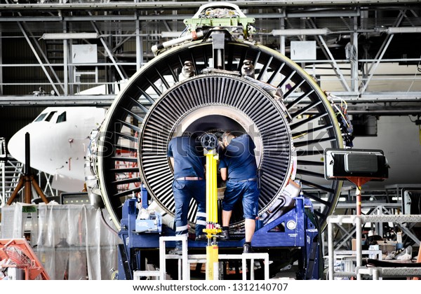 Jet engine remove from aircraft (airplane)\
for maintenance at aircraft hangar.Jet engine maintenance and\
change part by aircraft technician\
.