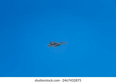 A jet fighter soars through a clear blue sky with wisps of clouds.
Keywords: jet fighter, blue sky, clouds, aviation, flight