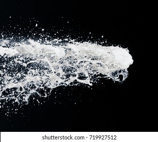 a jet of foam from a bottle of champagne on a black background. festive image - Powered by Shutterstock