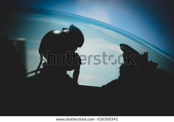 Jet pilot , The military\
pilot in the plane in a helmet in dark blue overalls against the\
blue sky