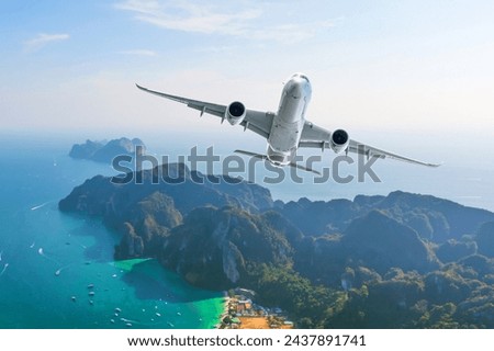 Jet plane fly over the tropical island. Panoramic view airliner landing take off flight to exotic islands in the warm ocean, vacation travel trip concept.
