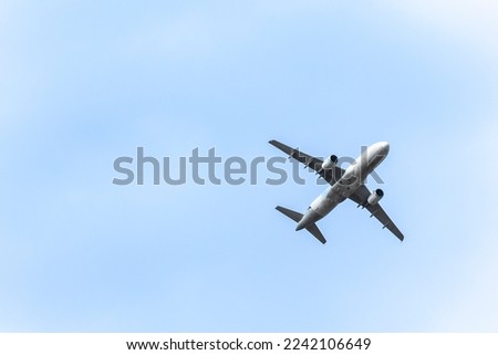 A jet plane flying in a blue sky between clouds. Transportation. Air travel.