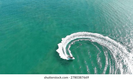 A jet ski performs a sharp circular maneuver on the turquoise waters of Tweed River.