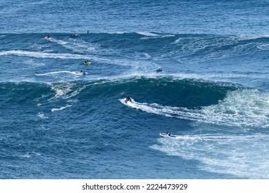 Jet Skis In The Water And Surfers Waiting For The Big Waves In Nazare, Portugal. Biggest Waves In The World. Touristic Destination For Surfing And Lovers Of Radical Sports. Amazing Destinations.
