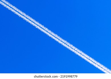 Jet Vapour Trials Against A Blue Sky Background