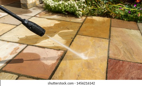 Jet Washing Natural Stone Paving Slabs In A Garden