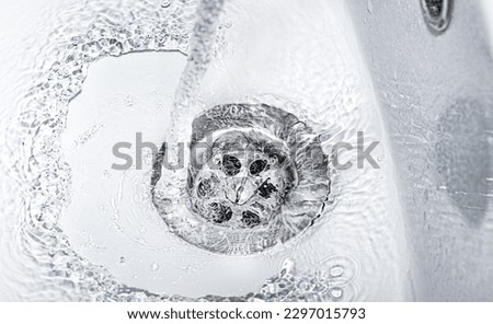 a jet of water flows into an open drain close-up