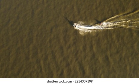 Jetski Tows Inflatable Toward Lake Bank, Top Down Aerial View